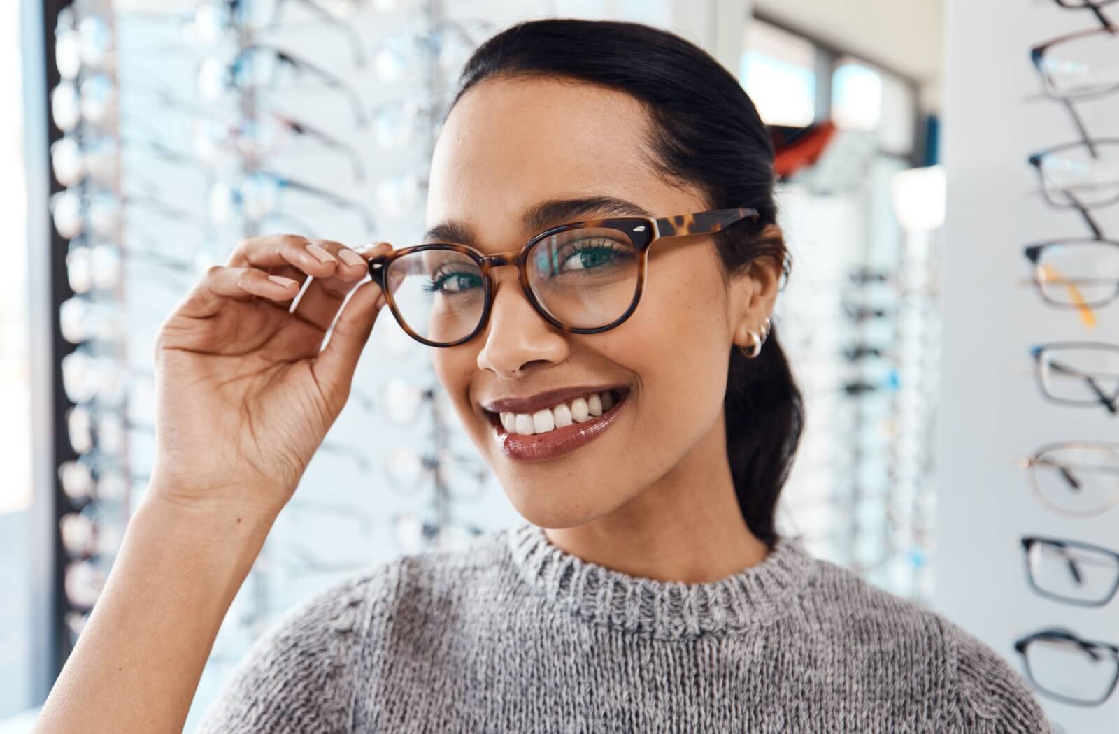 A person smiling while wearing eyeglasses that complement their face shape.